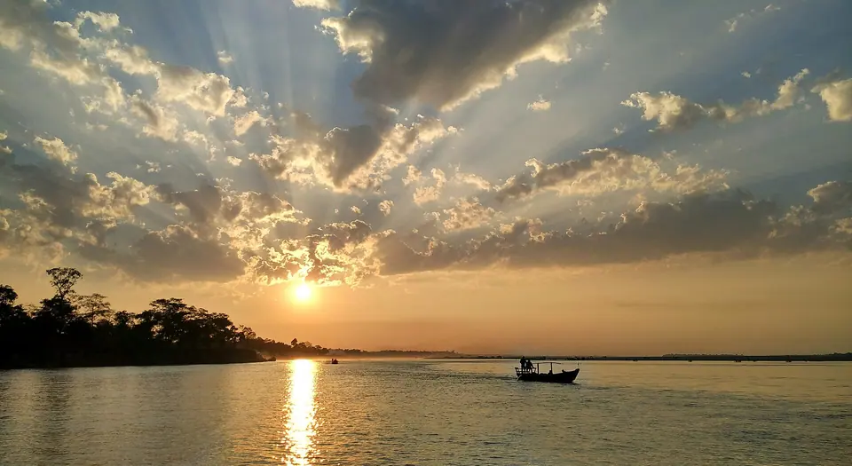 Sunbeams breaking through clouds over the Brahmaputra at sunset, seen from Dibru-Saikhowa