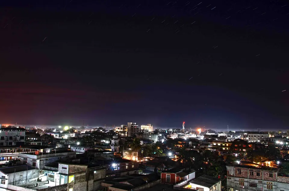 Lights of Dibrugarh town glowing under a dark night sky, seen from a rooftop
