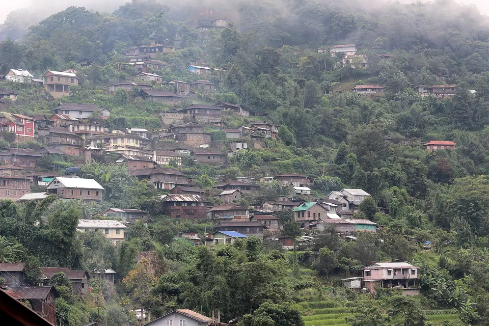 Khonoma's houses climbing a forested ridge under low cloud, near Kohima