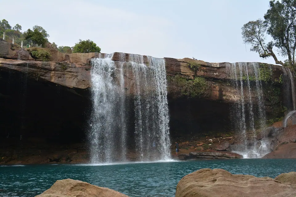 Krang Suri Falls pouring off a sandstone overhang into a deep blue-green pool, West Jaintia Hills