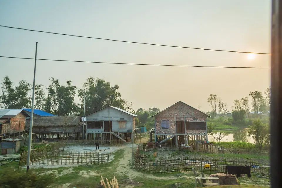 Mishing stilt houses of bamboo and timber beside a wetland on Majuli island at dusk