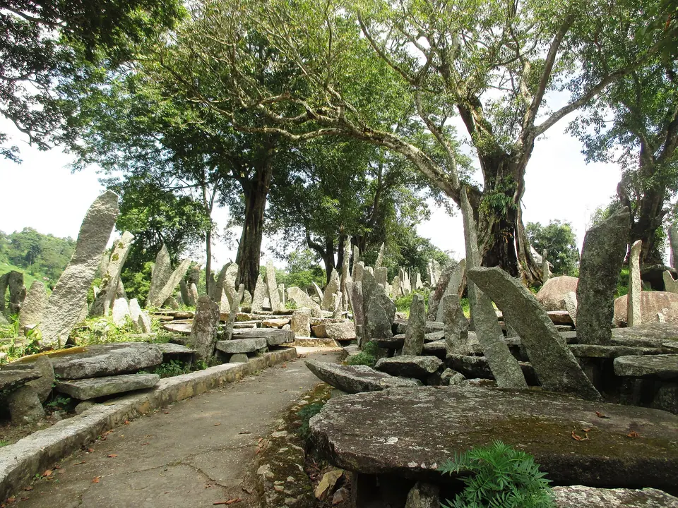 A paved path through the Nartiang monolith garden, lined with tall stone slabs and dolmens