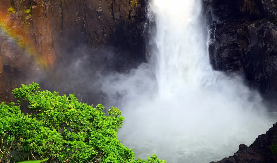 Langshiang Falls crashing into a white cloud of spray between dark cliffs near Nongstoin