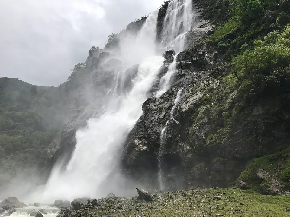 Close view of Nuranang Falls thundering over dark rock in clouds of spray