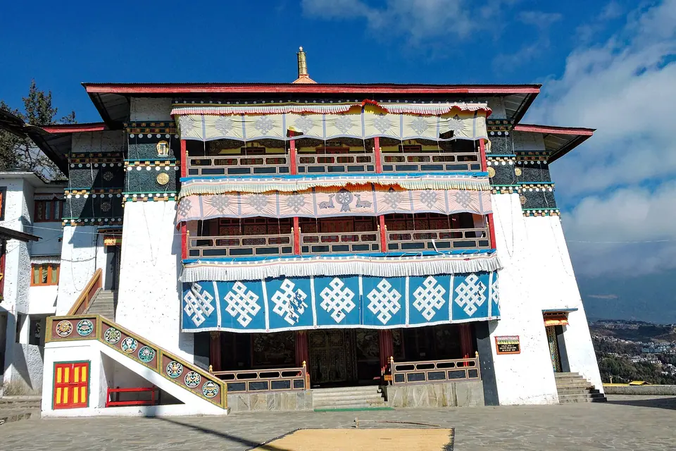 Front of the main Buddha temple at Tawang Monastery with painted windows and white walls