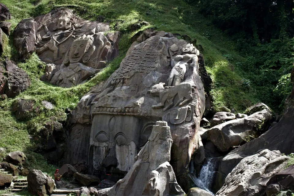 The giant rock-cut face of Unakotiswara Kal Bhairava among mossy boulders at Unakoti, Tripura