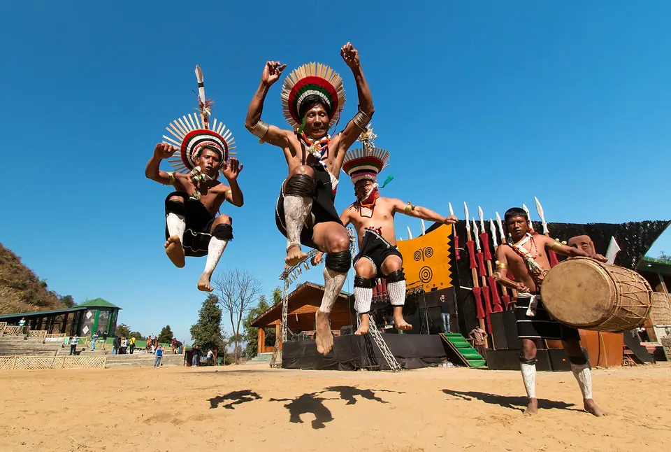 Zeliang Naga dancers leaping in feathered headdresses at the Hornbill Festival, Kisama, Nagaland